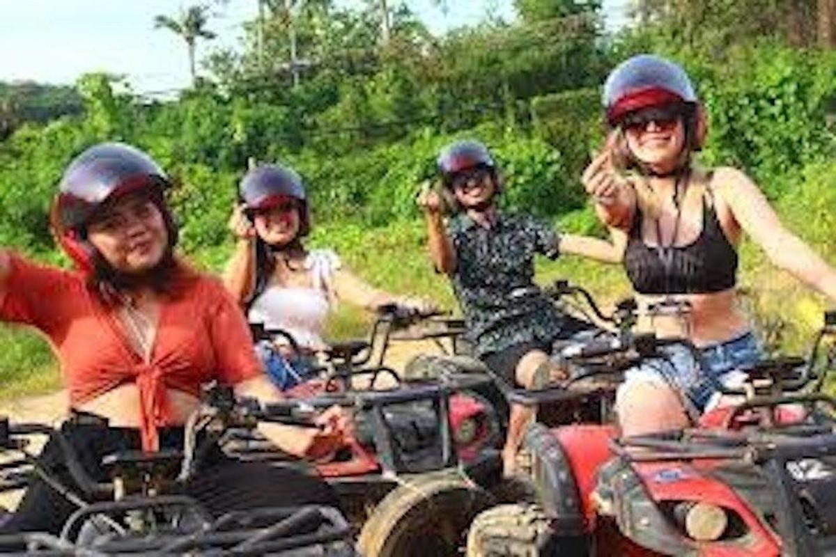 a group of people riding on four wheelers