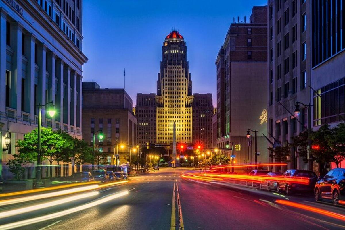a city street at night with a tall building
