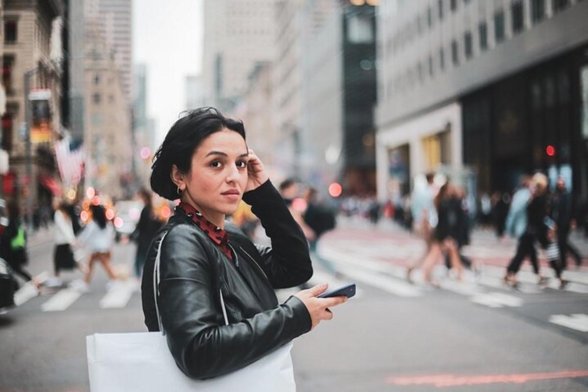 a woman in a leather jacket holding a cell phone
