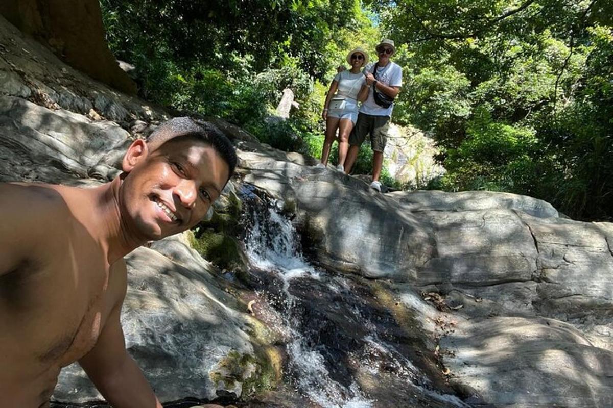 due uomini in piedi su una roccia vicino a una cascata