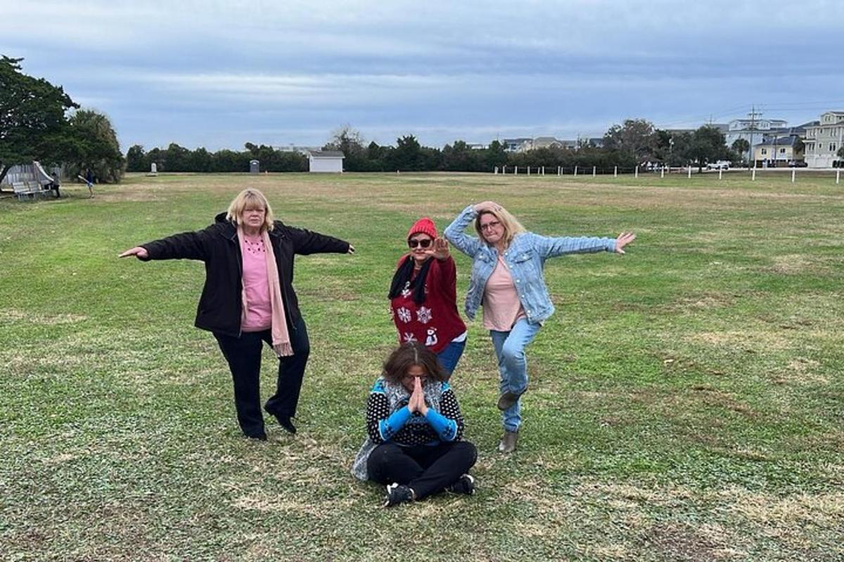 three women standing in a field with their arms outstretched