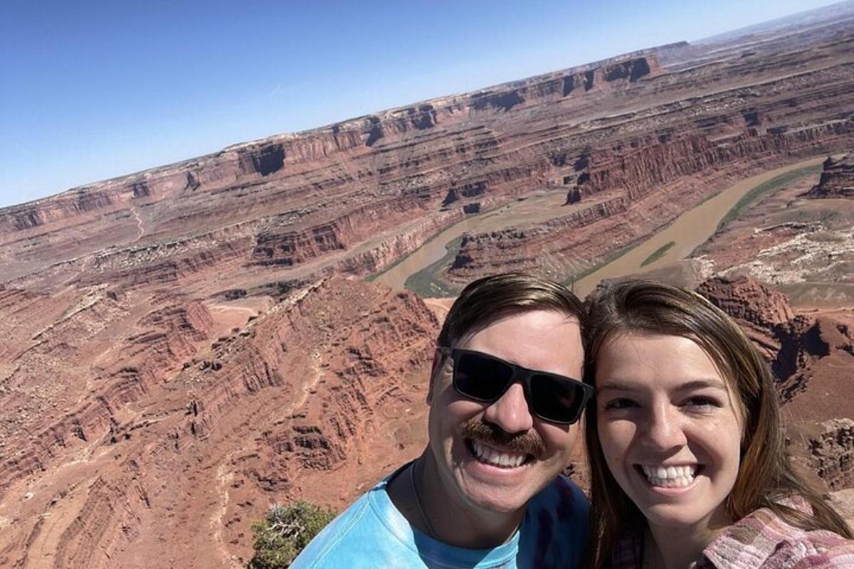a man and woman posing for a picture at the grand canyon
