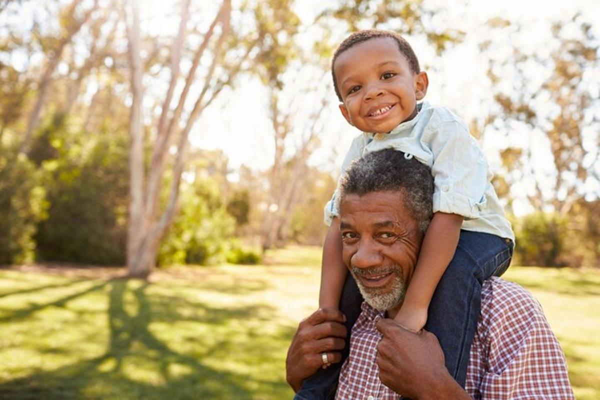 a man holding a child on his shoulders
