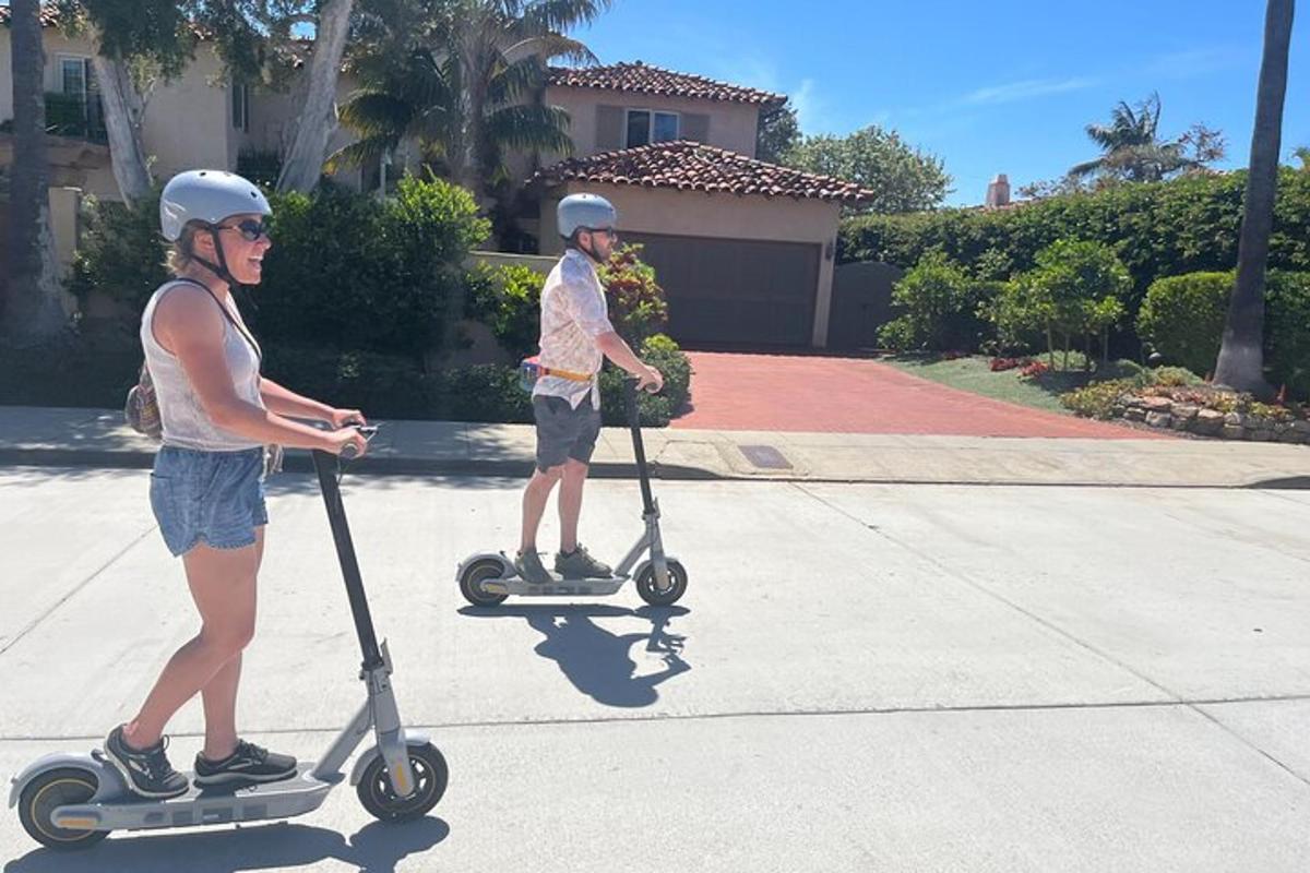 két sisakot viselő ember robogózik az utcán