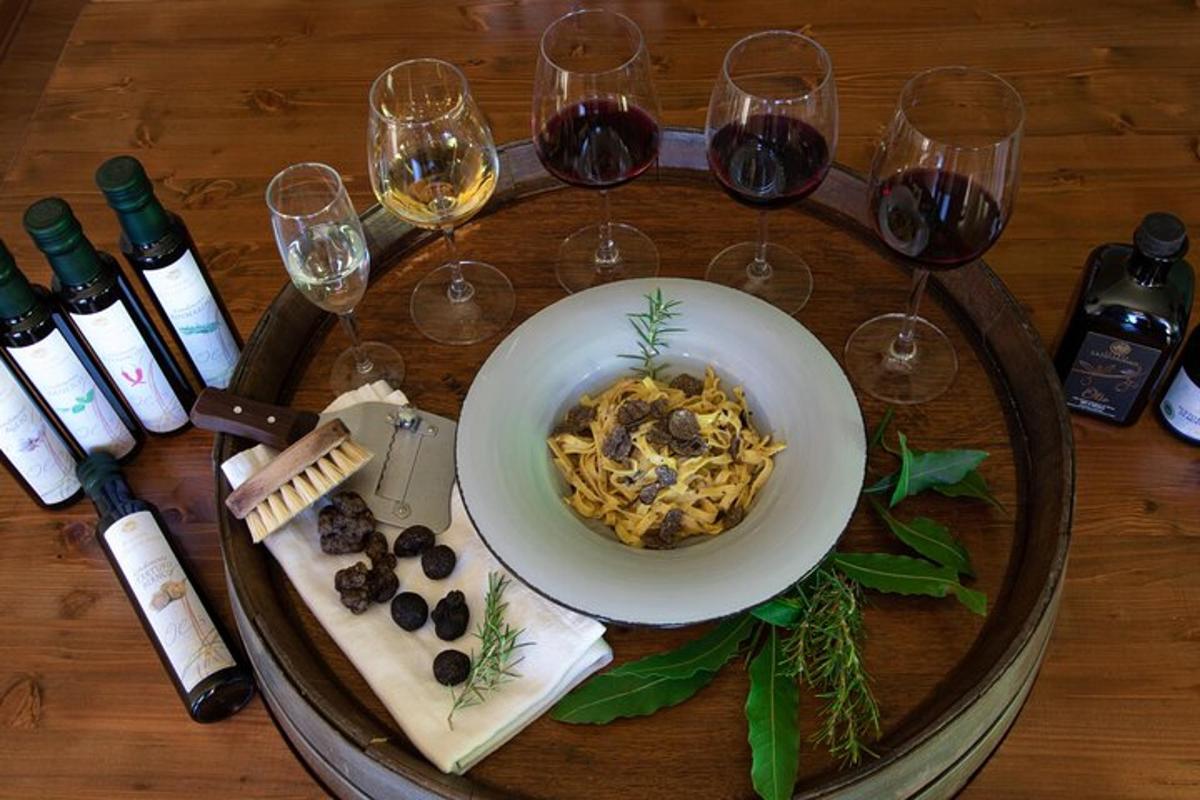 una taula amb un bol de pasta i copes de vi