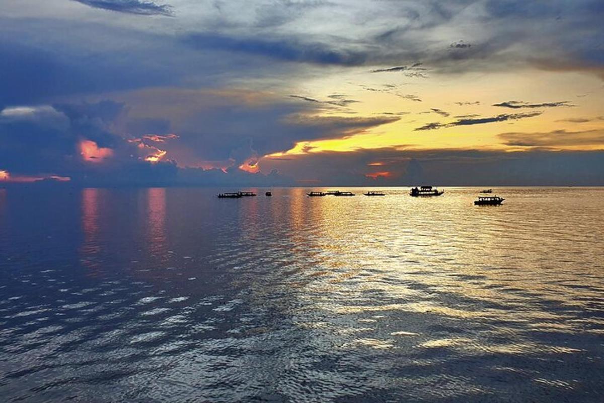 un gruppo di barche sull'acqua al tramonto