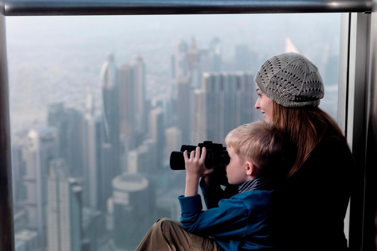 a woman and a child taking a picture of the city