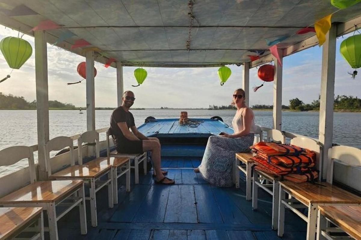 muž a žena sedící na zadní straně lodi