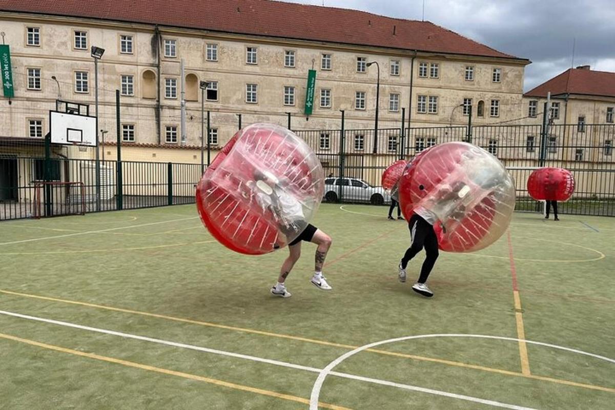 Du žmonės žaidžia aikštelėje su dideliais raudonais kamuoliais