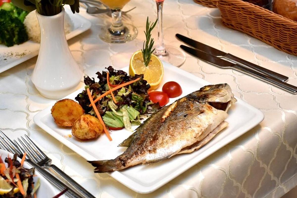 Un plato de pescado y ensalada en una mesa.