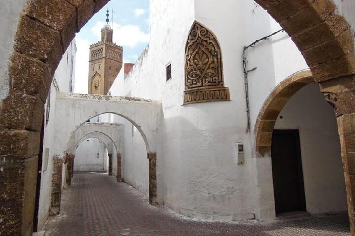 an alley way with a clock tower in the distance