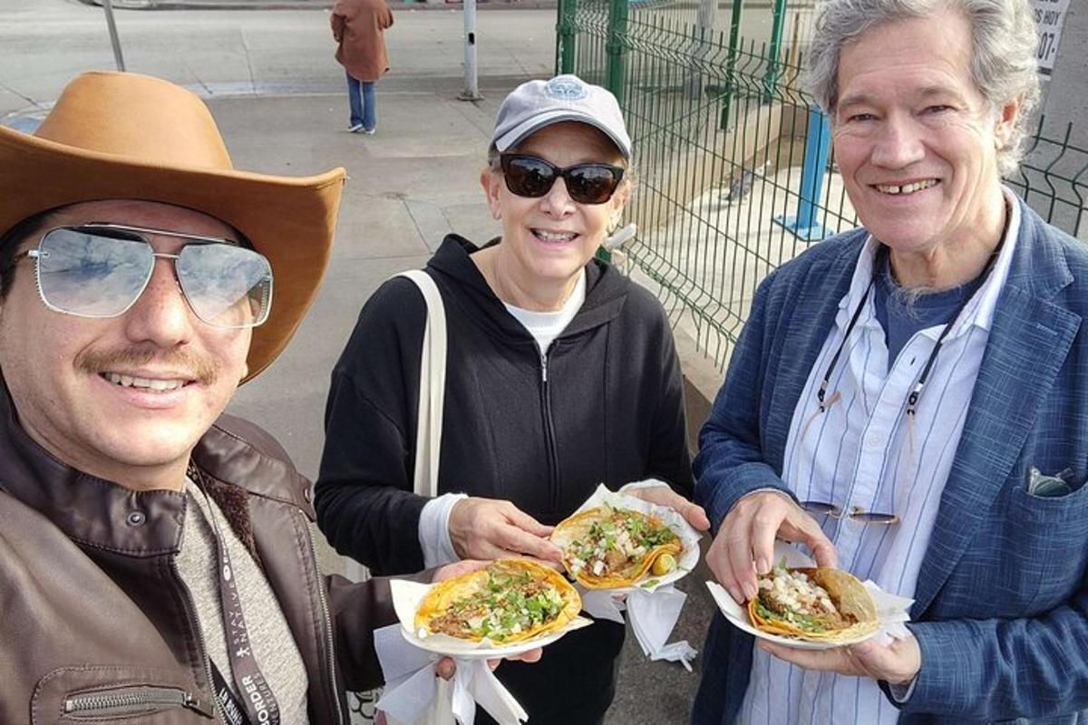 two men and a woman holding plates of food
