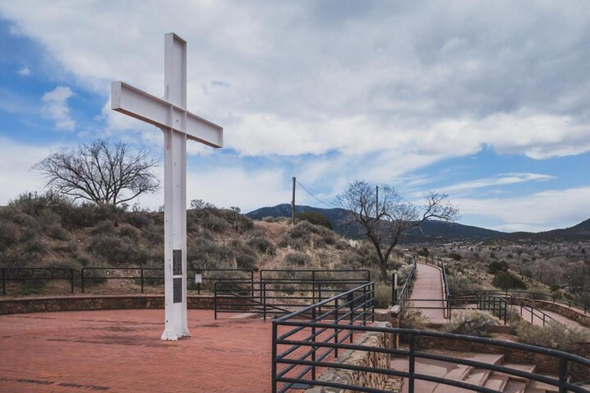 a large white cross on the side of a road