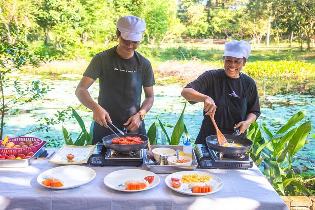 due uomini che cucinano il cibo su un tavolo con piatti pieni di cibo