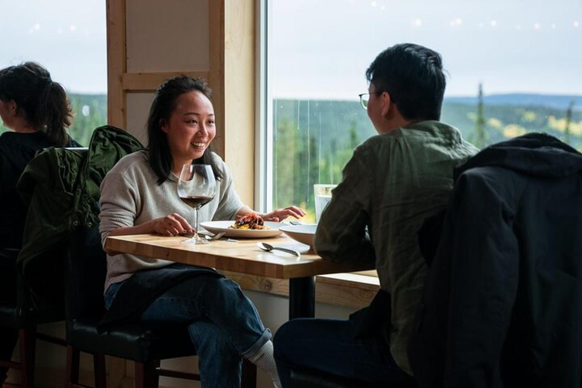 một người phụ nữ đang ngồi ở bàn với một ly rượu vang