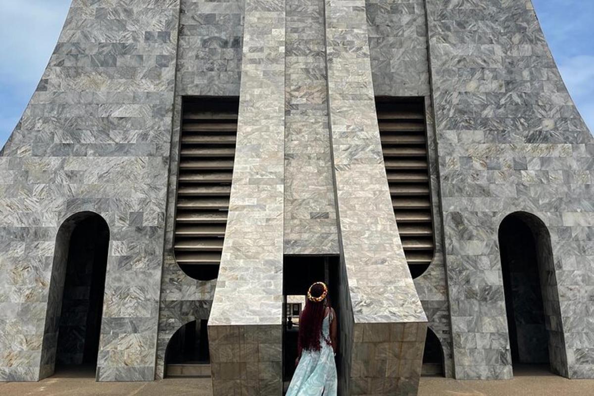 seorang wanita berbaju berdiri di hadapan sebuah bangunan