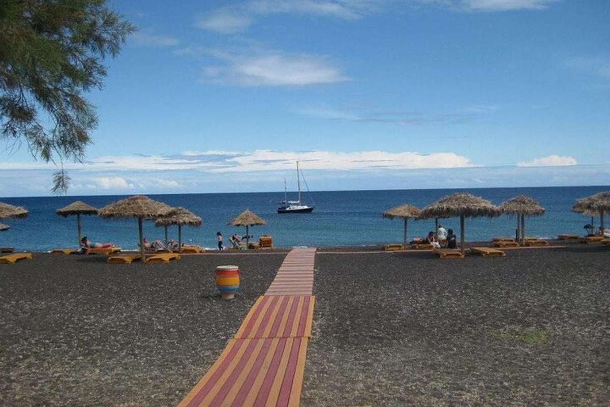 egy strand sok szalma napernyővel és az óceánnal