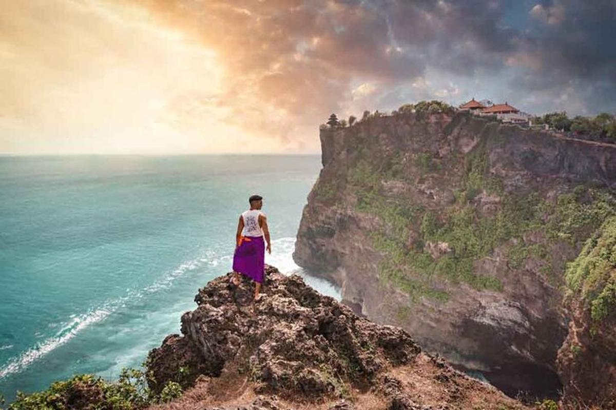a man standing on a cliff overlooking the ocean