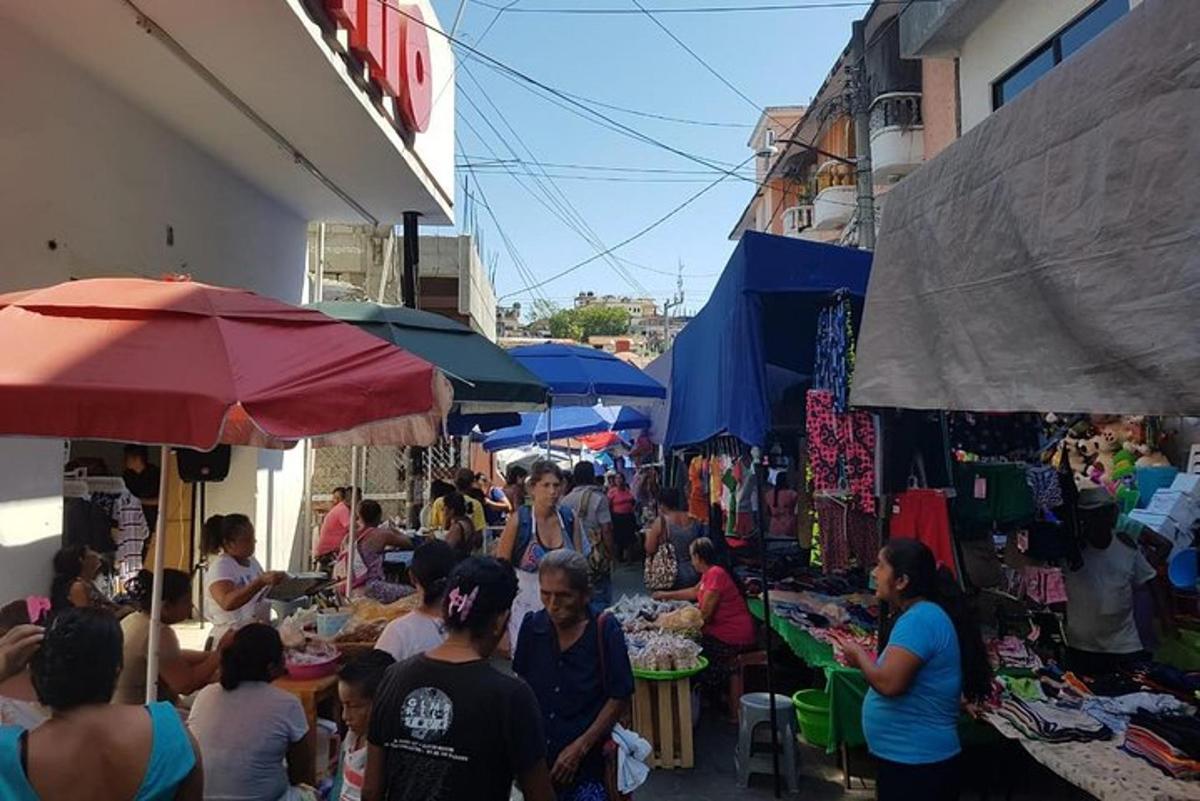 un grup de persones passejant per un mercat amb venedors