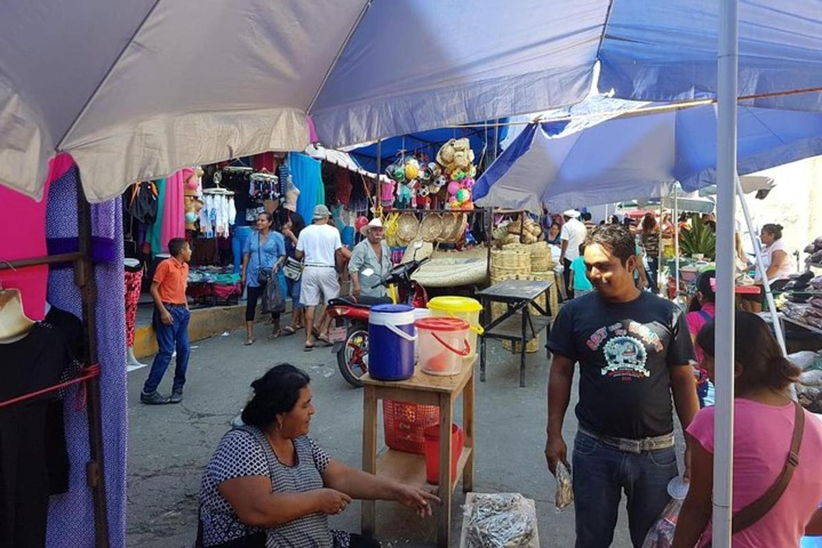un grup de persones passejant per un mercat a l'aire lliure