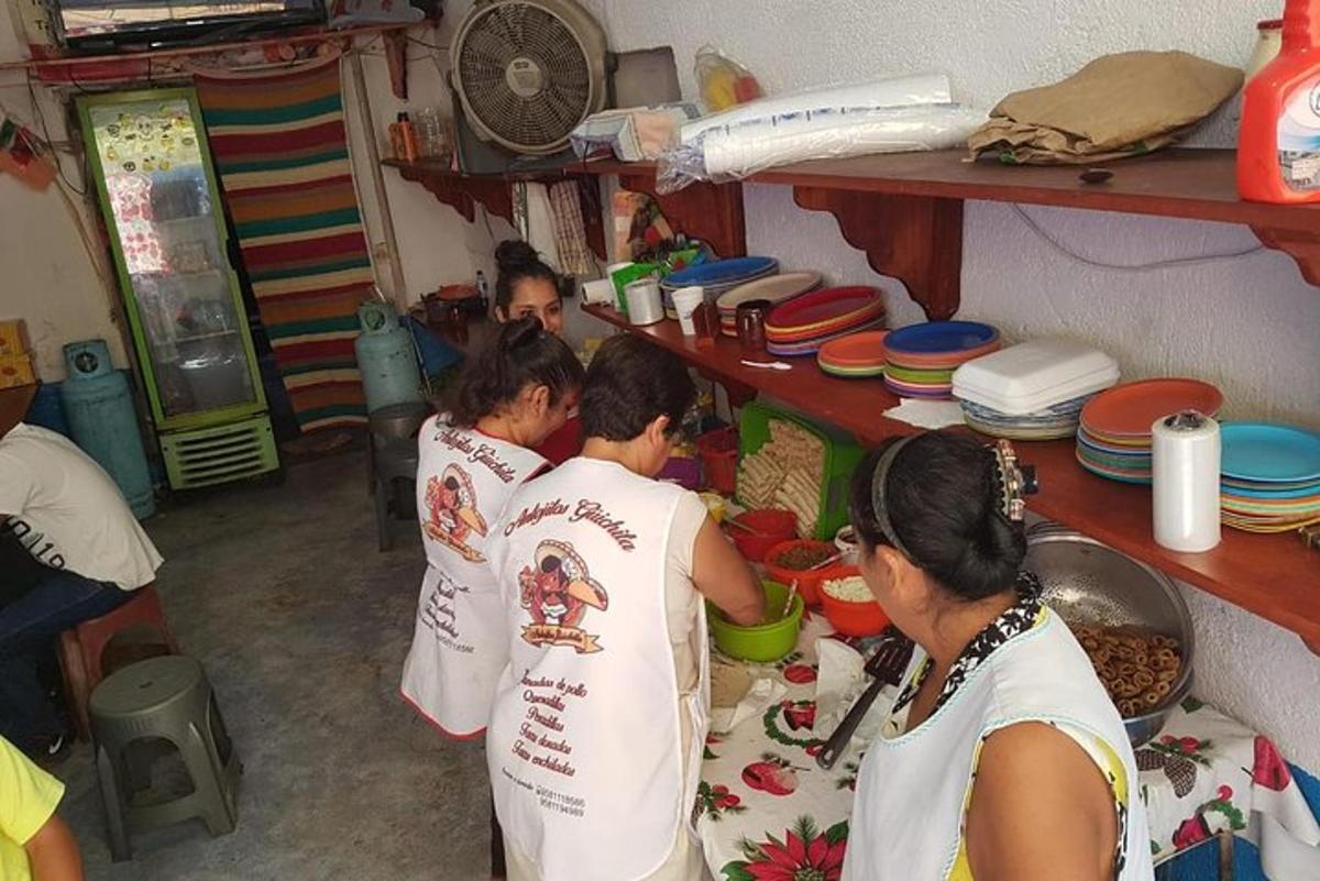un grup de persones a la cuina preparant menjar