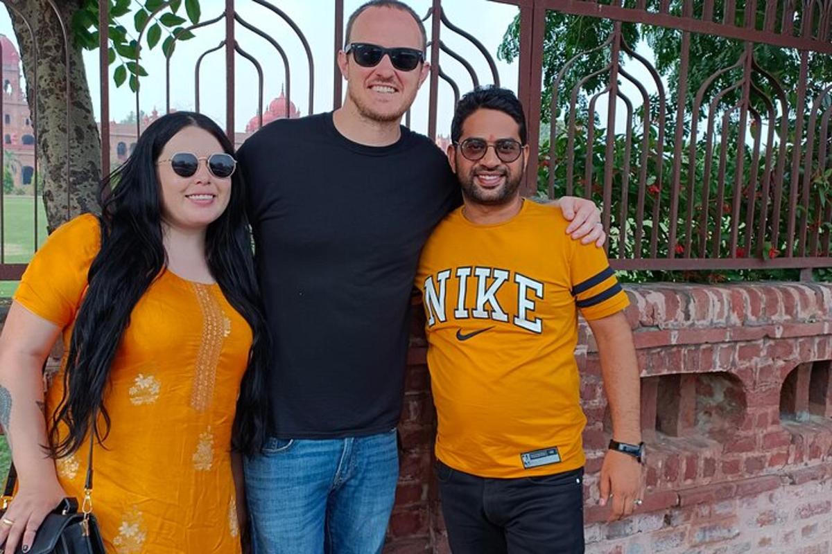 a group of three people standing in front of a gate