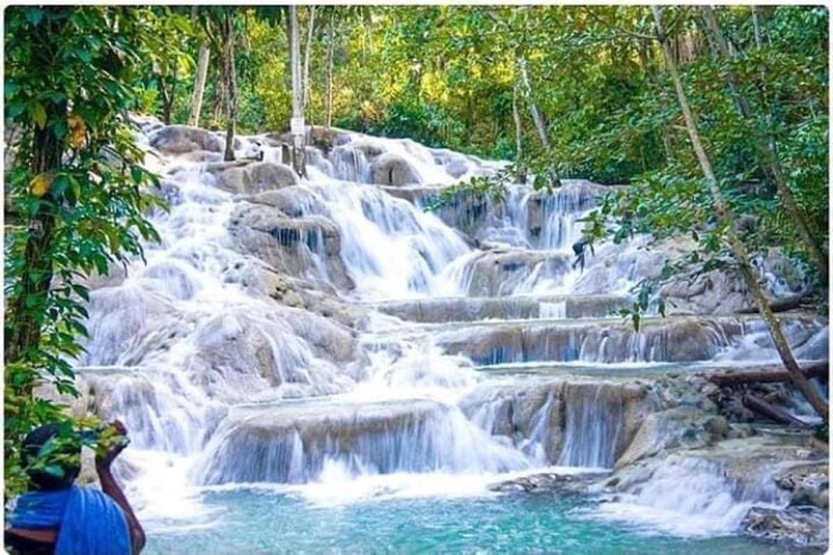 một người đàn ông đang chụp ảnh thác nước