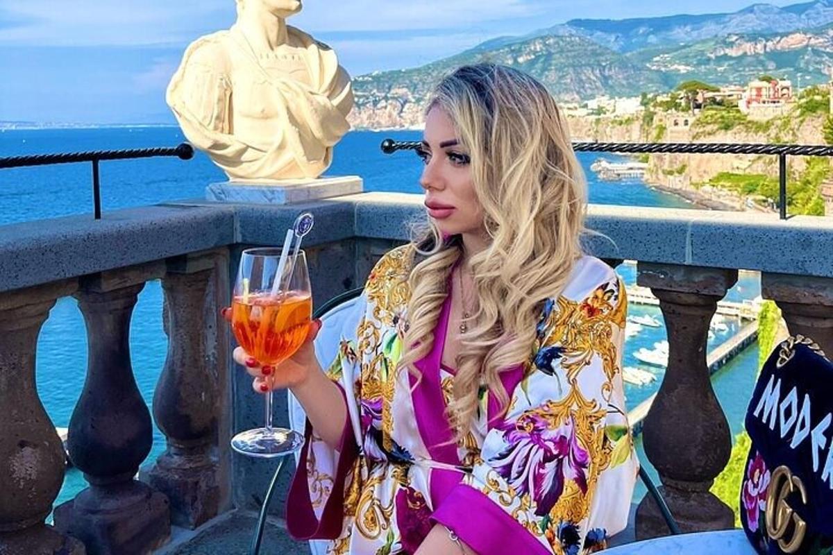 バルコニーに座ってワイングラスを持つ女性