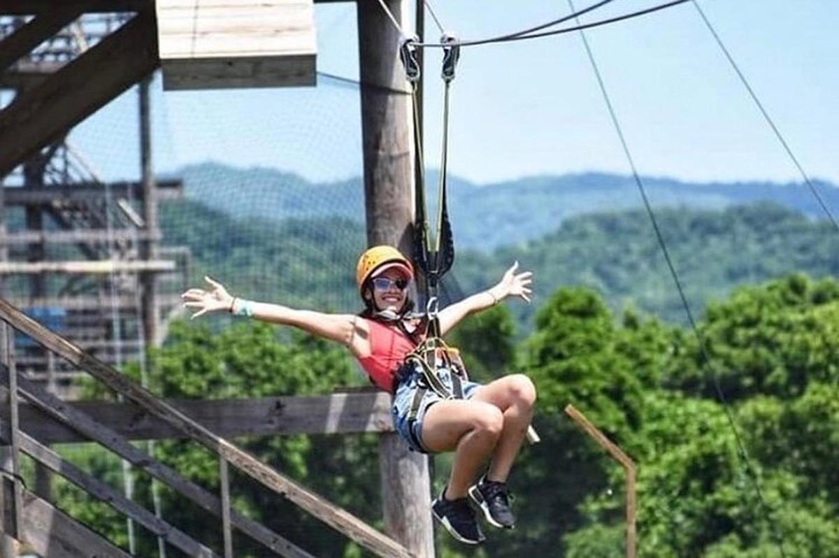 một người phụ nữ đang ngồi trên một đường dây zip