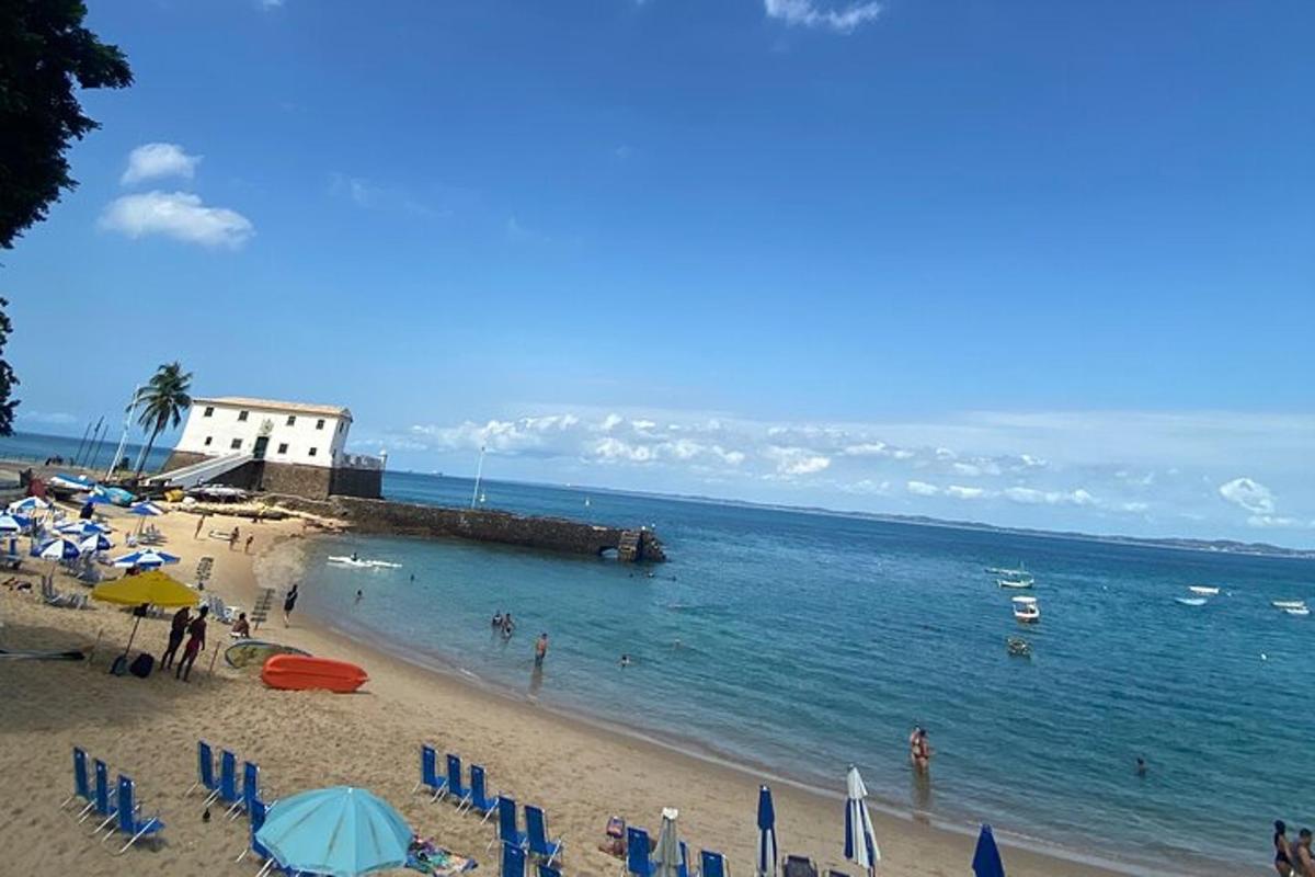 a beach with umbrellas and people in the water