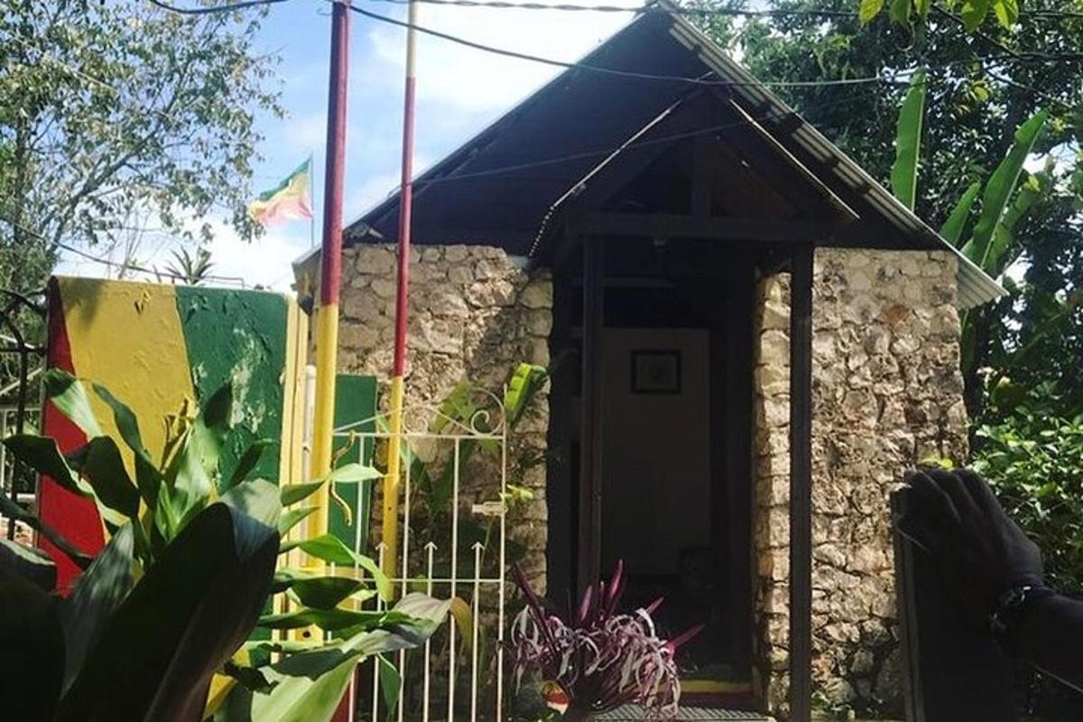 un piccolo edificio con una tenda da sole blu in un giardino