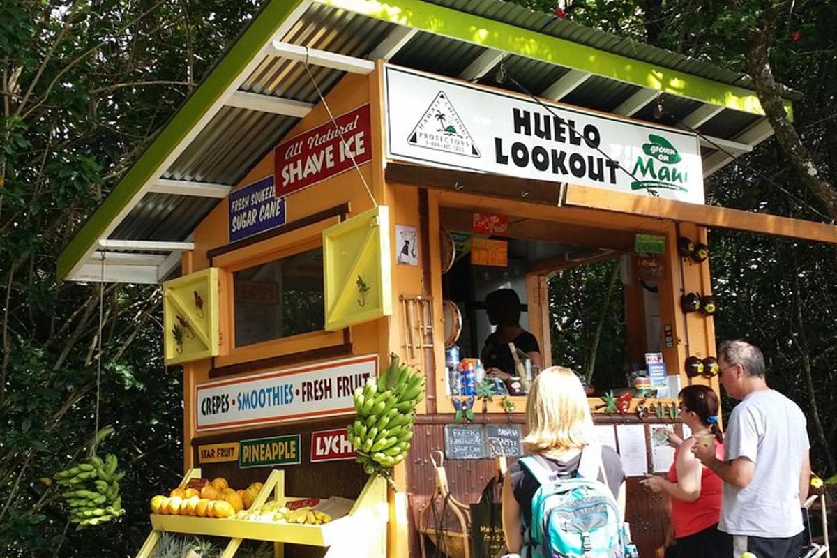 a group of people standing outside of a fruit stand