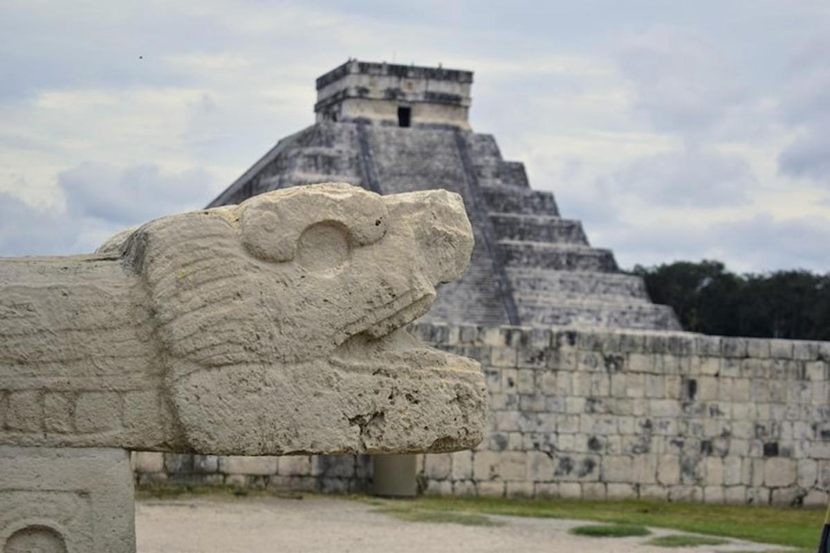 Una estatua de león de piedra frente a una pirámide