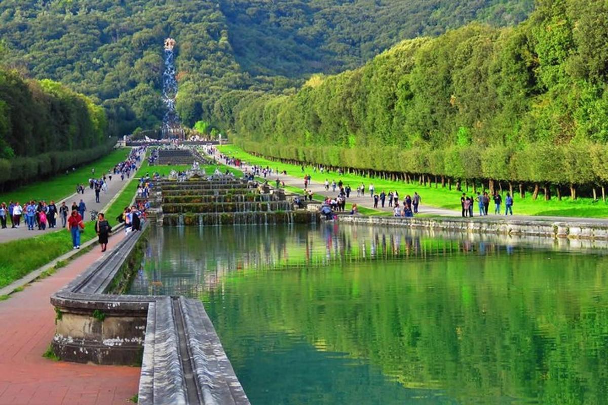 eine Gruppe von Menschen, die um einen Teich in einem Park spazieren