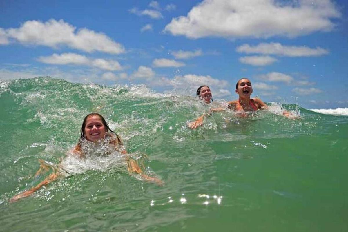 a group of three people swimming in the ocean