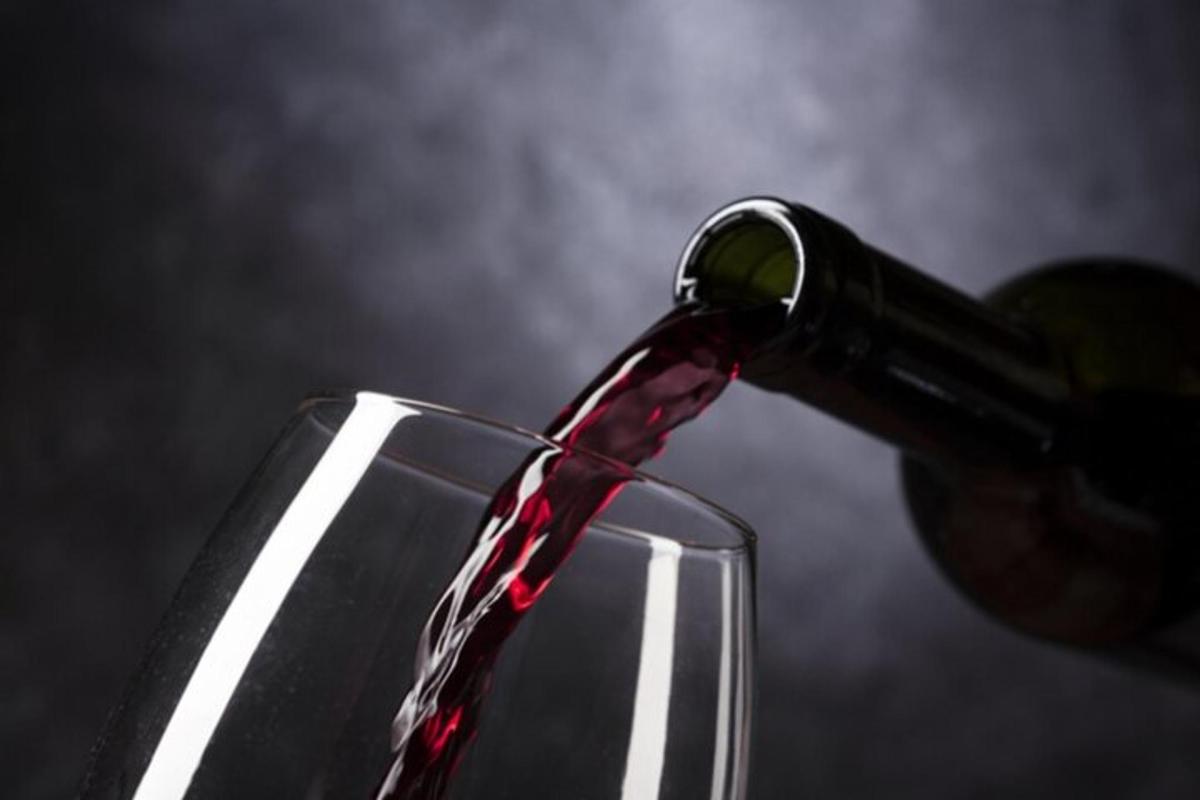 una bottiglia di vino rosso versata in un bicchiere