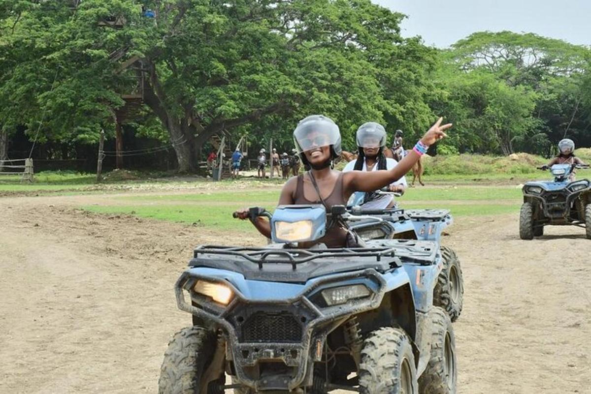 two people riding atvs down a dirt road