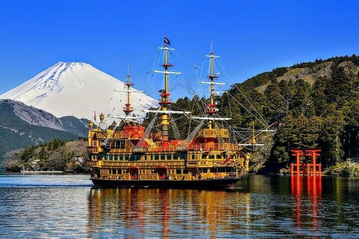um grande barco na água com uma montanha ao fundo