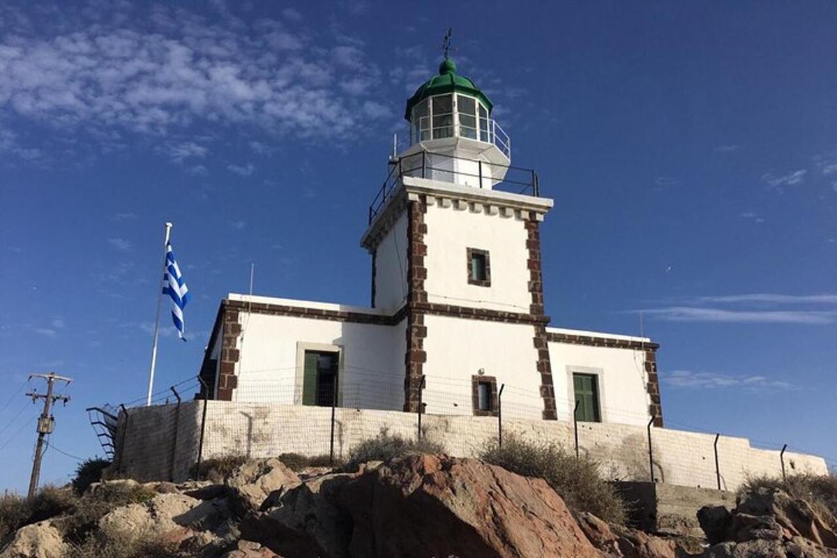 um farol no topo de uma colina com uma bandeira