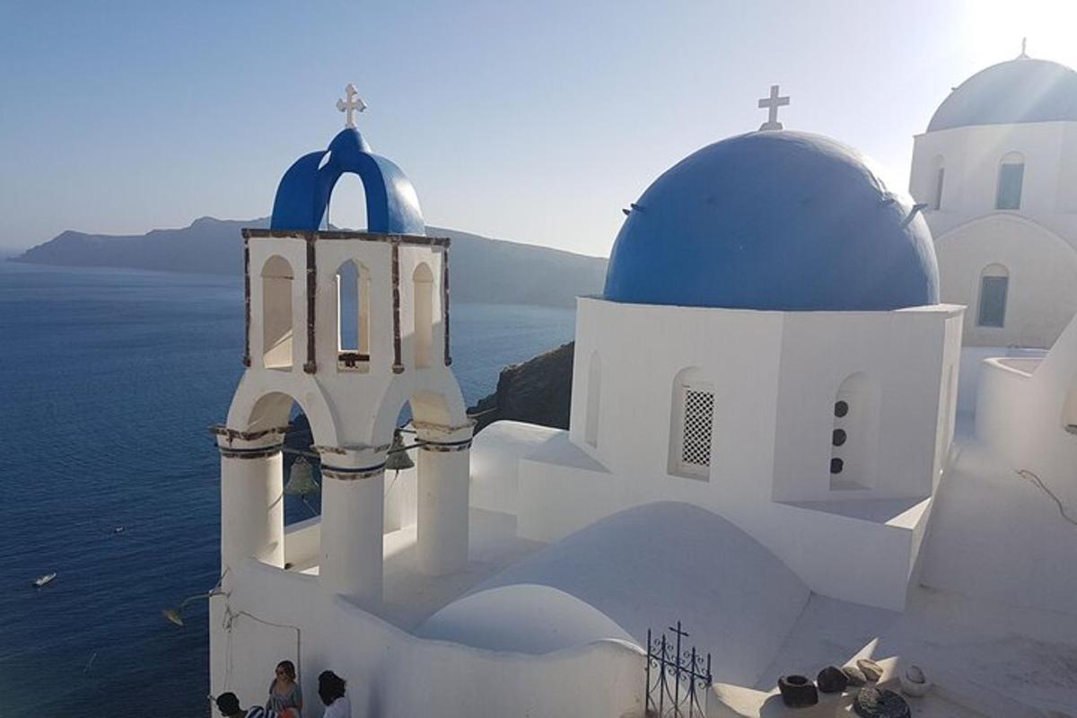 uma igreja com edifícios azuis e brancos e o oceano