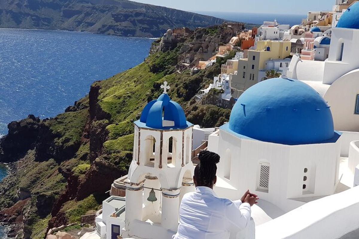 moški sedi na strani stavbe in gleda na ocean