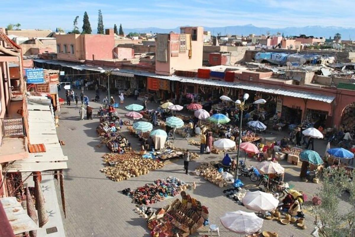 an outdoor market with a lot of people and umbrellas