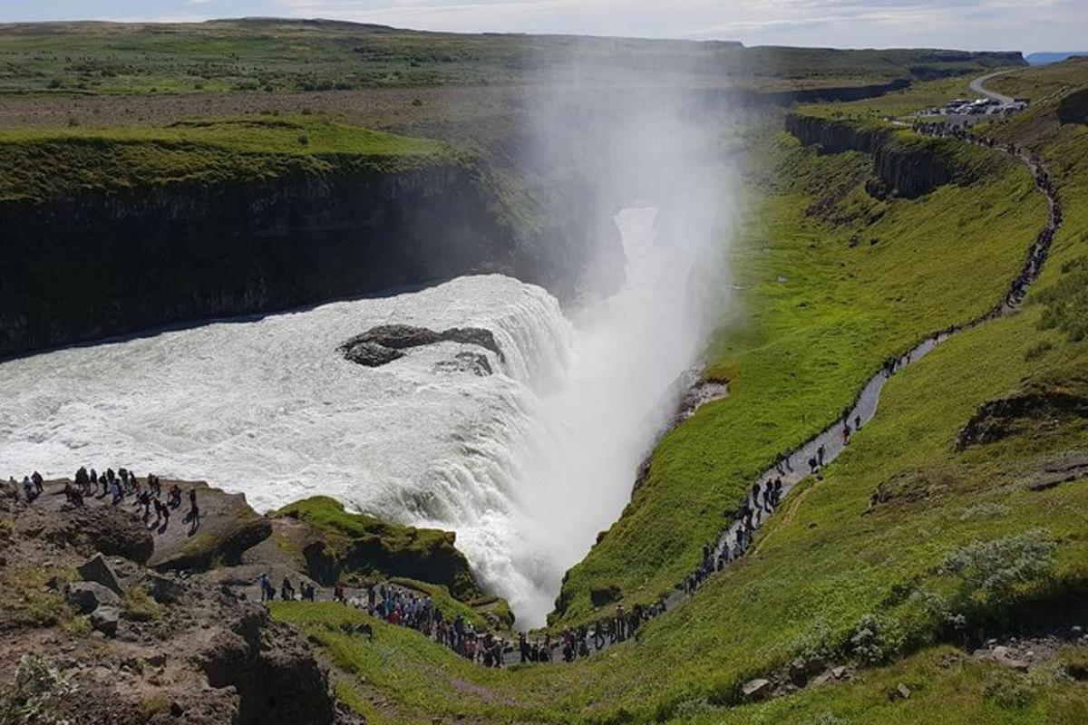 een groep mensen die voor een waterval staan