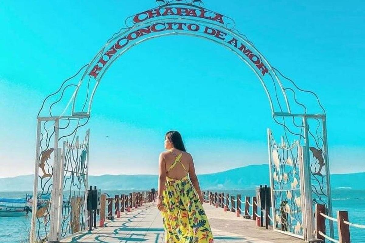 una donna in abito che cammina sotto un arco sopra l'acqua