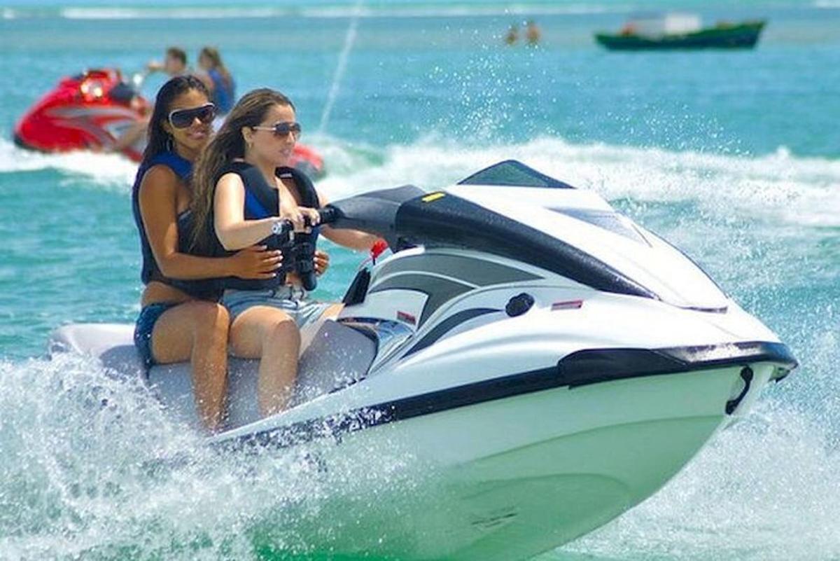 dues dones muntant una moto aquàtica a l'aigua