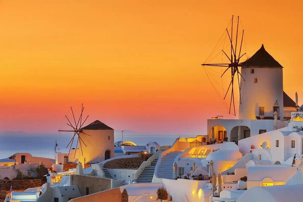 um pôr do sol sobre uma cidade com moinhos de vento e edifícios