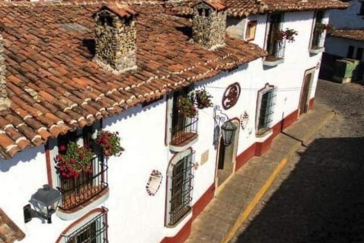 a white building with balconies and windows with plants