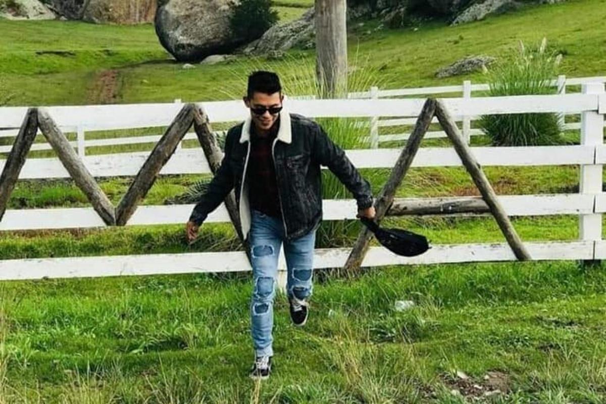 ένας άντρας περπατάει μπροστά από έναν φράχτη