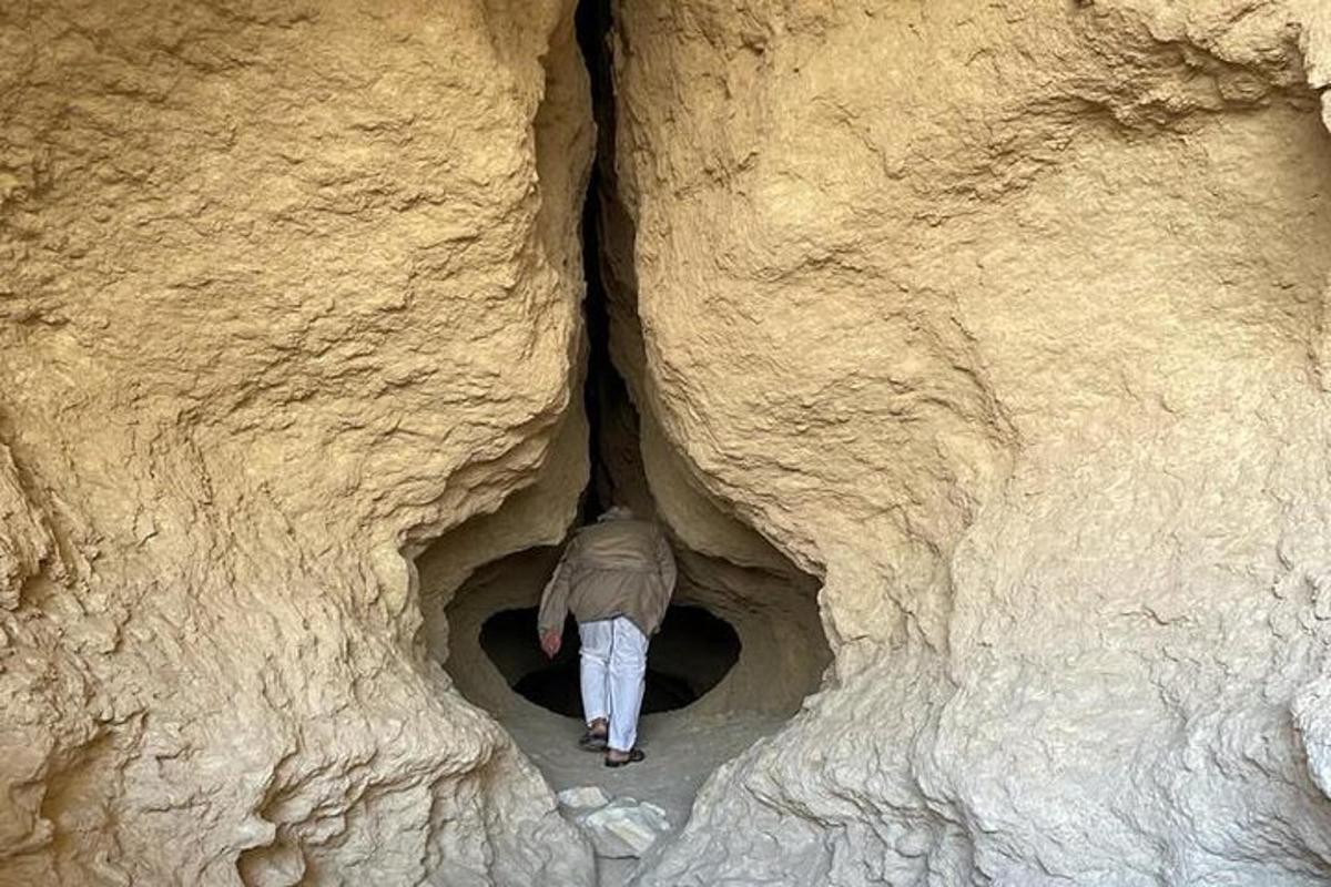 una persona caminando por un túnel en una formación rocosa