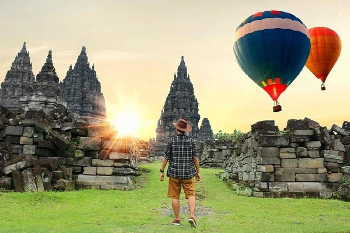 seorang pria menerbangkan dua balon udara di atas sebuah kuil